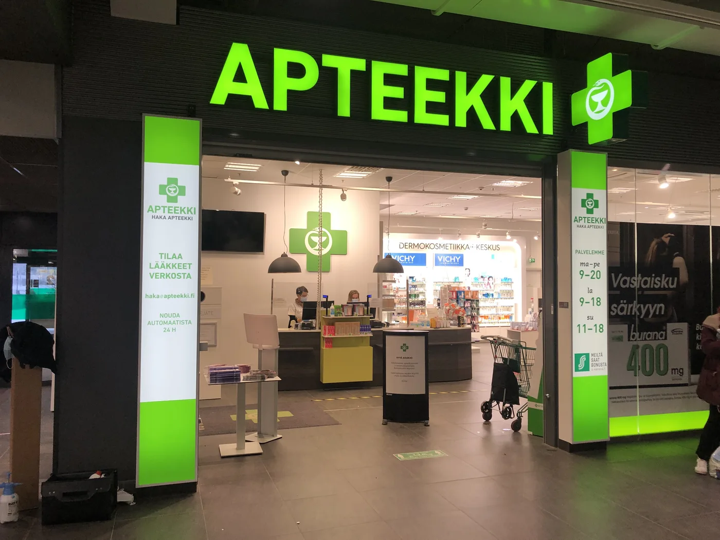 Haka Apteekin sisäänkäynti, valomainos ja pylvästeippaukset